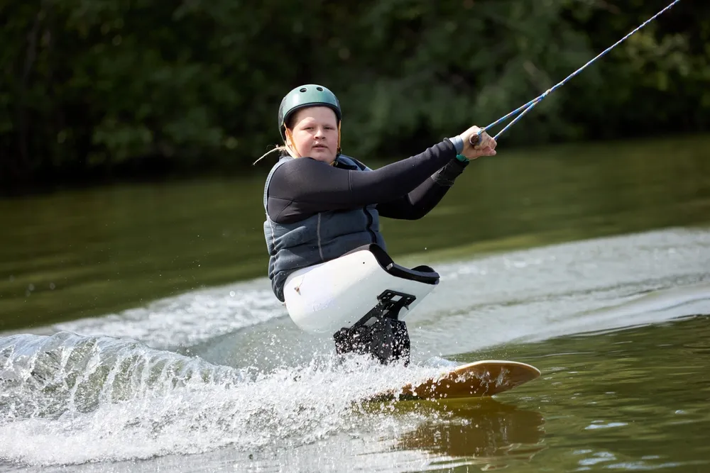 Young athlete building self-confidence in children with special needs during adaptive sports coaching