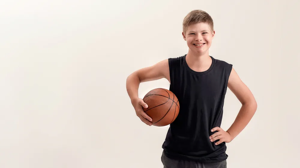 Coach helping build self-confidence in children with special needs through adaptive basketball practice